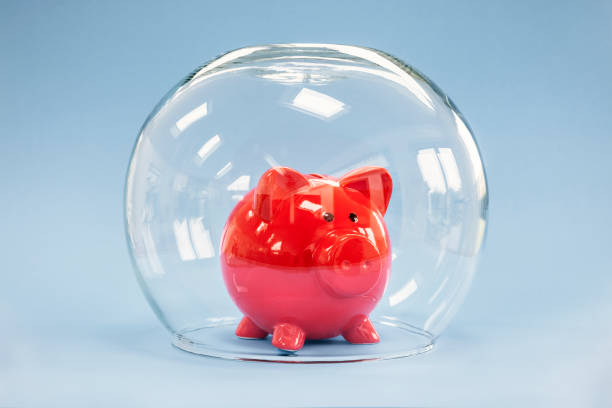 Protecting your savings, goldfish bowl covering a piggy bank stock photo