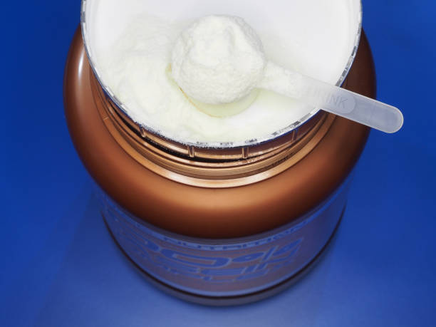 Protein powder, casein, glucosamine in a plastic spoon  for making a high-calorie drink on a plastic jar, blue background, closeup, top view. Healthy sports nutrition for fitness Protein powder, casein, glucosamine in a plastic spoon  for making a high-calorie drink on a plastic jar, blue background, closeup, top view. Healthy sports nutrition for fitness glucosamine stock pictures, royalty-free photos & images