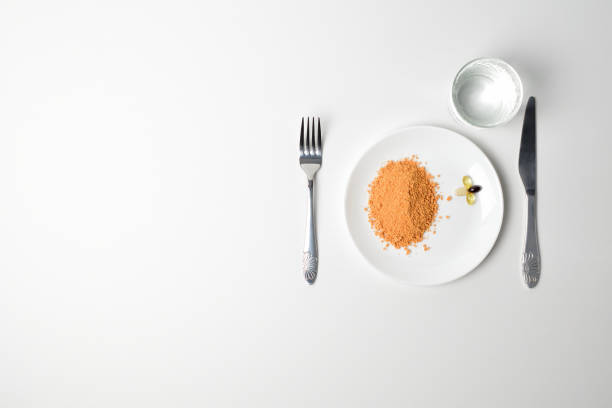 Protein powder on a plate Tomato protein soup powder and multivitamins on a plate. Meal replacement. Dry soup. Multivitamins, astaxanthin, fish oil, omega pills. pea protein powder stock pictures, royalty-free photos & images