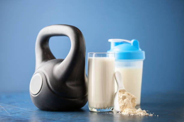 Protein sport shake and weight on blue background . Fitness food and drink. Diet. Copy space stock photo