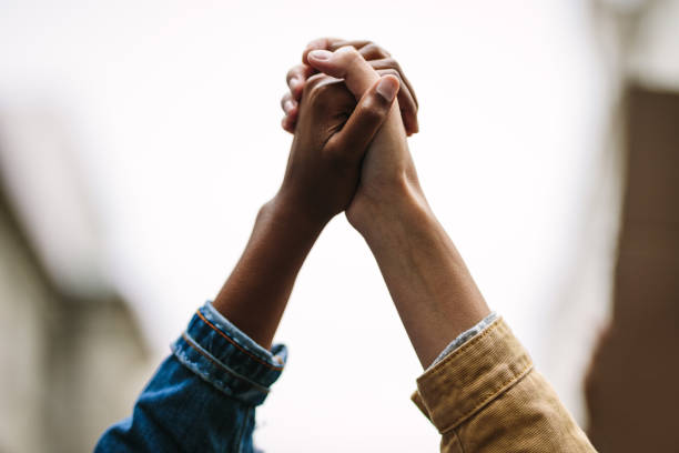 protest! protest protest. Black and white person holding hands for unity between races. unity stock pictures, royalty-free photos & images