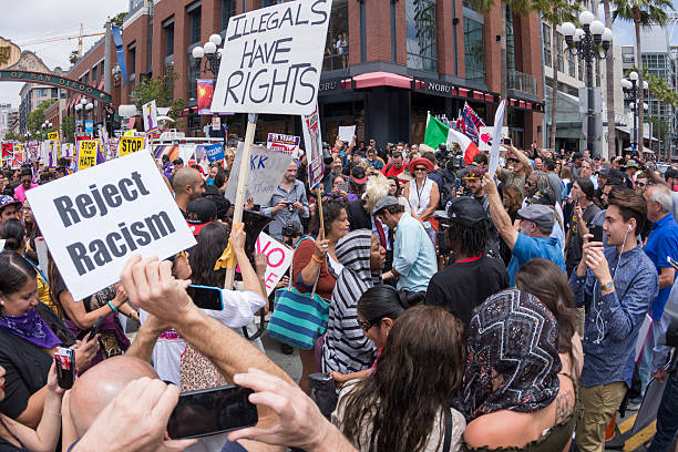 Protesters at anti-Trump demonstration in San Diego San Diego, California, USA - May 27, 2016: Hundreds of protesters gather in the Gaslamp area to display their thoughts about Donald Trump's presidential campaign at an anti-Trump demonstration. donald trump stock pictures, royalty-free photos & images