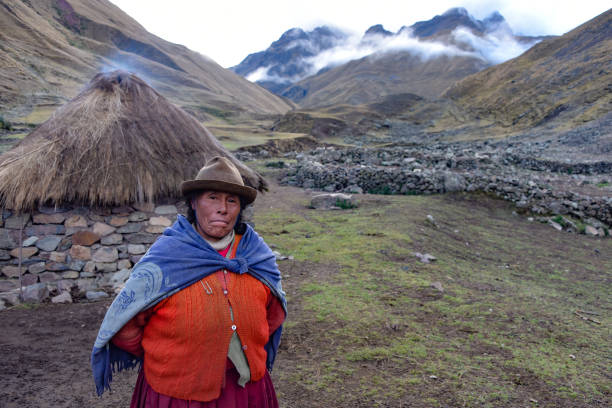 A proud Andean lady stands in front of her farm building in the remote Quesqe Valley. Cusco, Peru stock photo