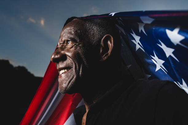 stolzer mann, der die flagge der vereinigten staaten von amerika hisst - us kultur stock-fotos und bilder