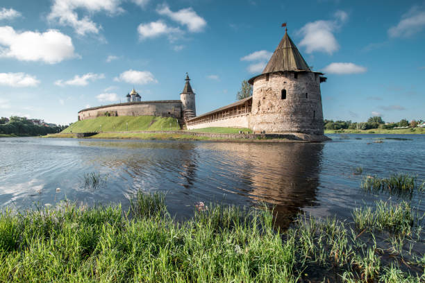 Pskov Kremlin against the backdrop of a bright blue sky in the summer. Ancient Russian architecture. Stone Watchtower. Pskov Kremlin against the backdrop of a bright blue sky in the summer. Ancient Russian architecture. Stone Watchtower. pskov russia stock pictures, royalty-free photos & images