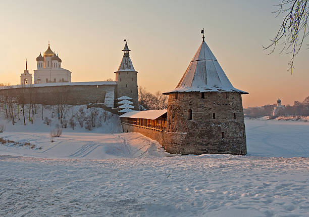 Pskov Kremlin in winter Trinity cathedral and huge watchtower (Flat Tower) of old Kremlin lit by the morning sun in winter in Pskov , Russia pskov russia stock pictures, royalty-free photos & images