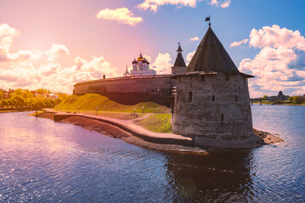Pskov kremlin tower with blue cloudy sky in background. River in foreground. Pskov kremlin tower with blue cloudy sky in background. River in foreground. pskov russia stock pictures, royalty-free photos & images