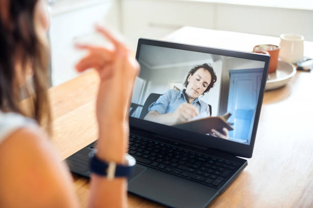 Psychologist making notes during online session with patient Psychotherapist seen on laptop screen writing on clipboard while listening to the female patient during an online counselling session online psychology stock pictures, royalty-free photos & images