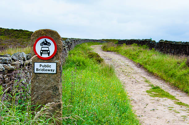 Public bridleway red and white sign post in English countryside