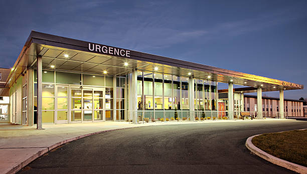 Public hospital emergency entrance driveway with French sign Public hospital emergency entrance driveway with French sign at dusk. entrance sign stock pictures, royalty-free photos & images