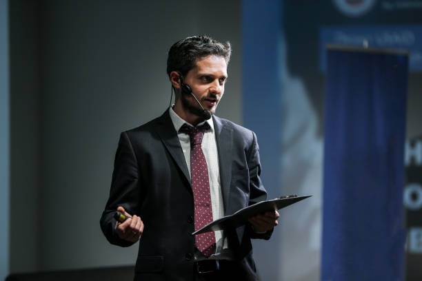 Public speaker giving talk at Business Event Attractive and confident successful man with headset speaking at corporate business coaching and training conference.Business and Entrepreneurship event,motivation training speaker stock pictures, royalty-free photos & images