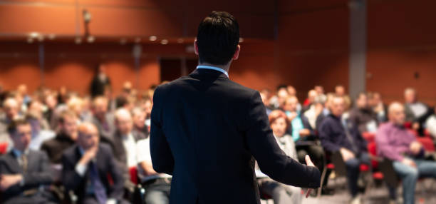 Public speaker giving talk at business event. stock photo
