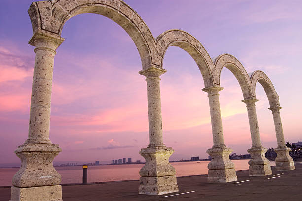 Puerto Vallarta Beachfront Boulvard &quot;Los Arcos&quot; Mounument A sunrise shot of the arches landmark in downtown Puerto Vallarta, Mexico.  View of Banderas Bay in the background.  Horizontal orientation.  Arches were placed by the city; no specific artist's name attatched. puerto vallarta stock pictures, royalty-free photos & images
