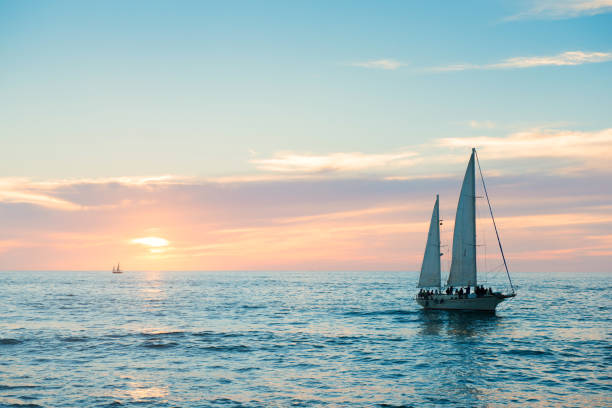Puerto Vallarta Sailboat in Pacific Ocean at Sunset Mexico This is a horizontal, color photograph shot in travel destination, Puerto Vallarta, Mexico. A sailboat moves through the Pacific Ocean at sunset as it drives back toward the docks. puerto vallarta stock pictures, royalty-free photos & images