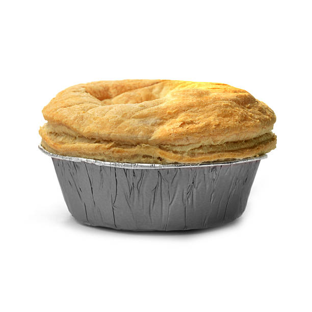 Puff Pastry Pie Isolated puff pastry meat pie with a foil base. Concept image for fast food, junk food or comfort food. Soft shadows against a white background. Copy space. meat pie stock pictures, royalty-free photos & images
