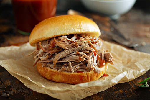 Pulled pork sandwich on a soft brioche bun with bbq sauce and pickles