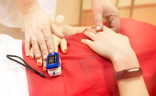 pulse oximeter on the patient's hand. surgery equipment - cor saturada imagens e fotografias de stock