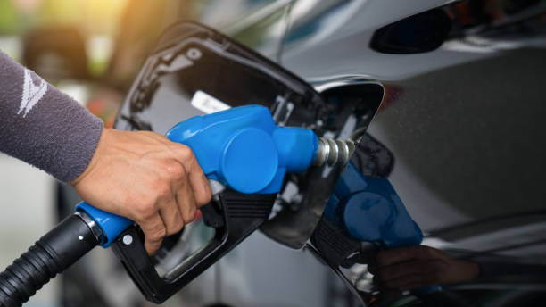 Pumping gas at gas pump. Closeup of man pumping gasoline fuel in car at gas station. stock photo