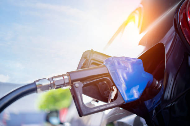 Pumping gasoline fuel in black car at gas station stock photo