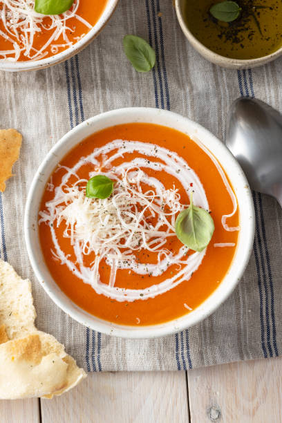 Pumpkin and carrot soup with cream on blue stone background. stock photo