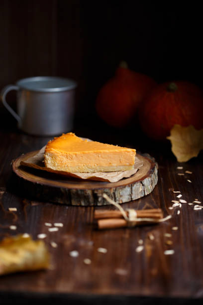Pumpkin cheesecake, cooked at home, cup of coffee, pumpkin, plum, vanilla , foliage on a wooden dark table stock photo