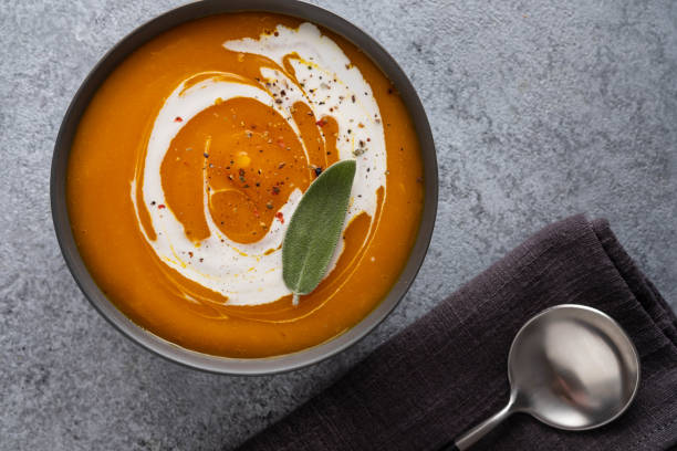 Pumpkin soup with sage on grey background. Top view. stock photo