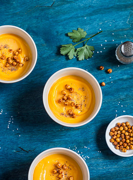 Pumpkin soup with spicy baked chickpea. On a wooden table stock photo