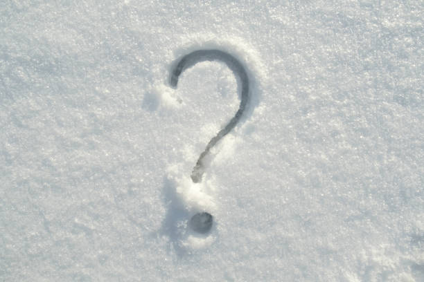 Punctuation question mark drawn on the fresh snow on a sunny winter day. stock photo