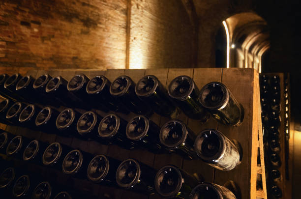 pupitre e bottiglie di vino all'interno di una cantina sotterranea - langhe foto e immagini stock