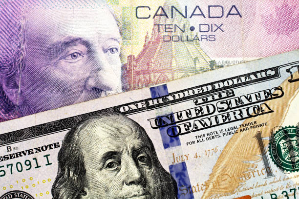 A purple Canadian ten dollar bill with an American one hundred dollar bill stock photo