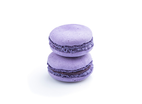 Purple macarons or macaroons cakes isolated on white background. Side view, close up.