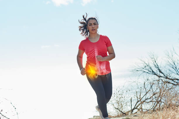 Pushing through the pain Shot of an attractive young woman running outdoors with her hip injury highlighted pelvis photos stock pictures, royalty-free photos & images