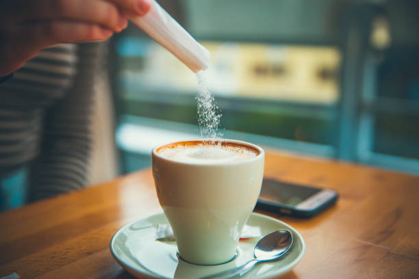 Put sugar in coffee cup stock photo