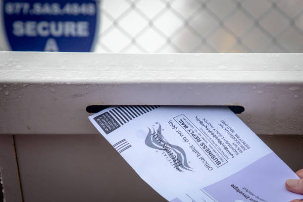Putting a mail in ballot into the drop off ballot box stock photo