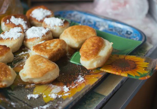 класть шпатель готовых жареных пончиков на блюдечке - belgorod стоковые фото и изображения