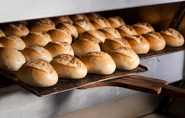 Putting buns in oven Baking fresh bread in bakeryMore photos from bakery and cakes: bun bread photos stock pictures, royalty-free photos & images