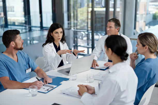 Putting medical matters on the table Shot of a group of doctors having a meeting in a modern hospital medical occupation stock pictures, royalty-free photos & images