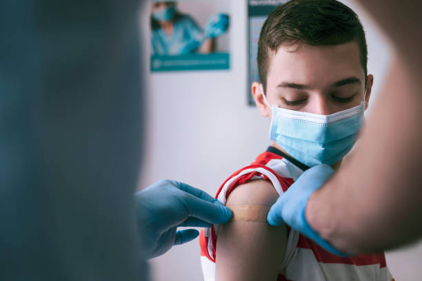 Putting plaster to a teenager after vaccination stock photo