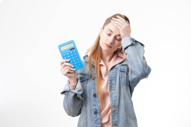 Puzzled woman student with calculator isolated on white background stock photo