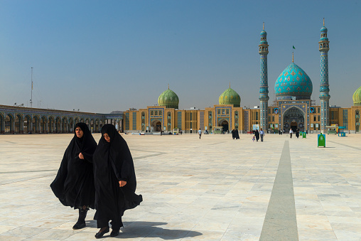 Qom- Iran. -may 14,2013: Muslim women with long robe in the courtyard of the Jamkaran Mosque. Jamkaran Mosque is a few kilometers outside the city of Qom and is in the south.