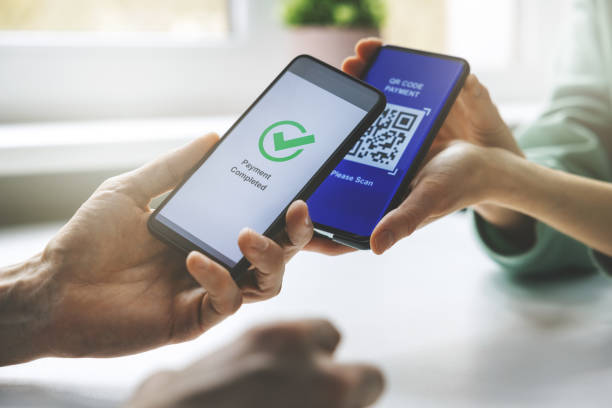 qr code payment - person paying with mobile phone stock photo