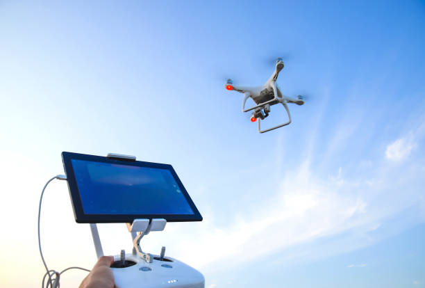 quadrocopters dan remote control untuk itu. quadrocopters terhadap langit biru. umravlenie quadrocopters - drone operator potret stok, foto, & gambar bebas royalti