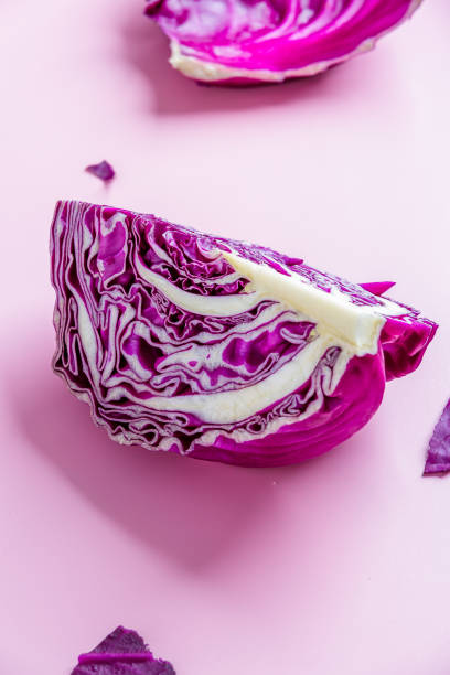 A quarter of purple cabbage on pink  background. stock photo