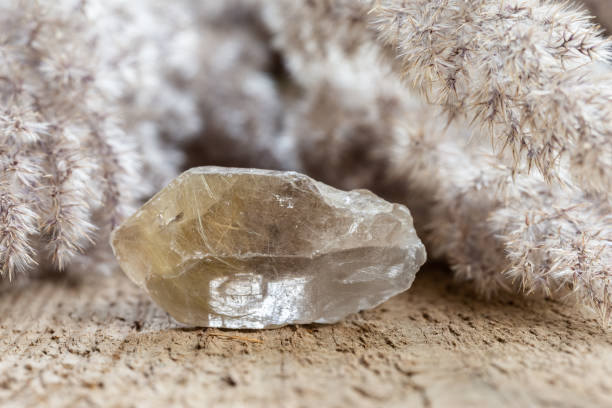 quartz with rutile crystal mineral stone on wood stock photo