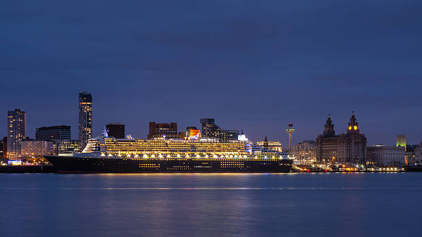 Queen Mary 2 Liverpool, England - May 24, 2015: Cunard cruise liner Queen Mary 2 docked in Liverpool and pictured at dusk as part of celebrations to mark Cunard's 175th anniversary. cunard building liverpool stock pictures, royalty-free photos & images