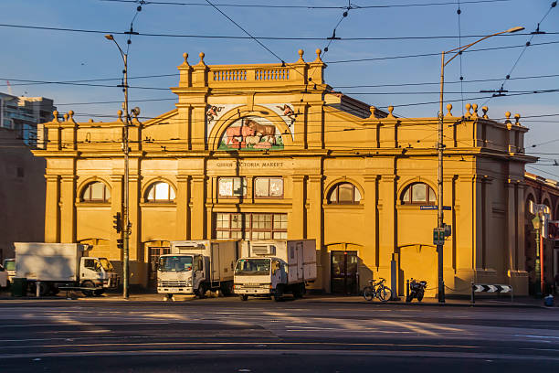 Queen Victoria Market at sunrise Melbourne, Australia - October 3, 2015: Trucks parked outside the Meat and Fish Hall building, Queen Victoria Market, at dawn on a Saturday. queen victoria market stock pictures, royalty-free photos & images
