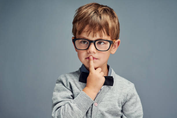 Question everything Studio shot of a smartly dressed little boy looking thoughtful against a gray background boys glasses stock pictures, royalty-free photos & images