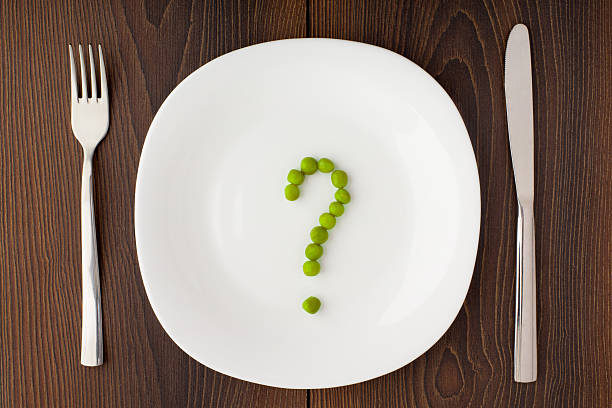 Question mark made of peas on plate stock photo