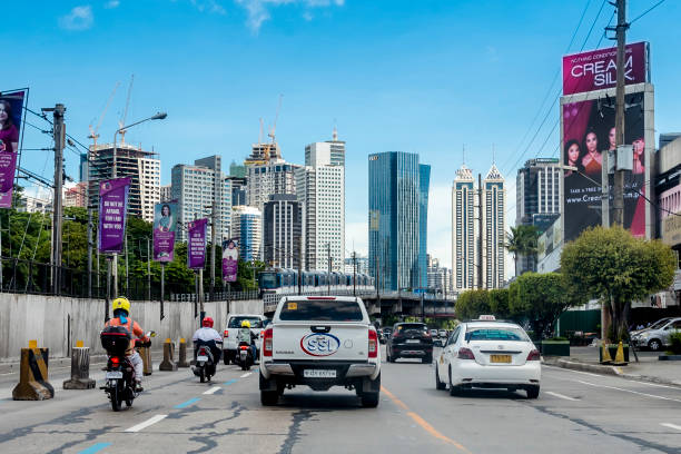 Quezon City, Philippines - Ortigas Skyline as seen from EDSA southbound coming from Greenhills. Incoming MRT train northbound. Driver's point of view. stock photo