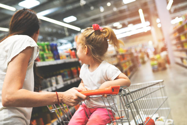 A quick mom with a daughter in a supermarket stock photo